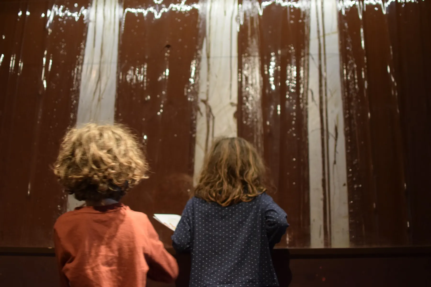 Enfants découvrant les secrets du chocolat avec une borne tactile à la Cité du Chocolat Valrhona